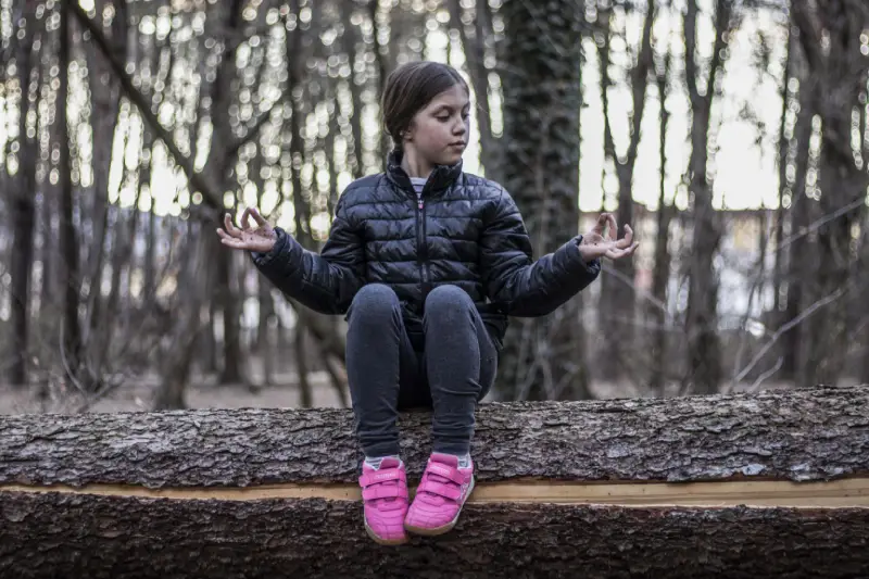 example of your photo of a girl sitting in the woods in winter.